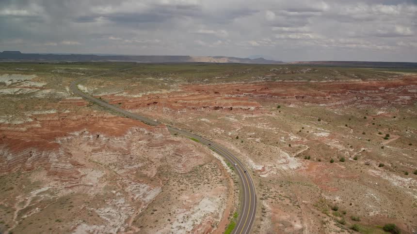  aerial footage of Highway 89 capturing the stunning rock formations of Glen Canyon National Recreation Area as we approach them from an aerial perspective during a partly cloudy day in Utah and Arizona