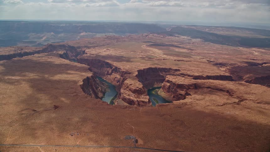 A stunning aerial view of Horseshoe Bend and the Colorado River in Glen Canyon Arizona showcasing the natural beauty of the Southwest United States during a sunny summer day
