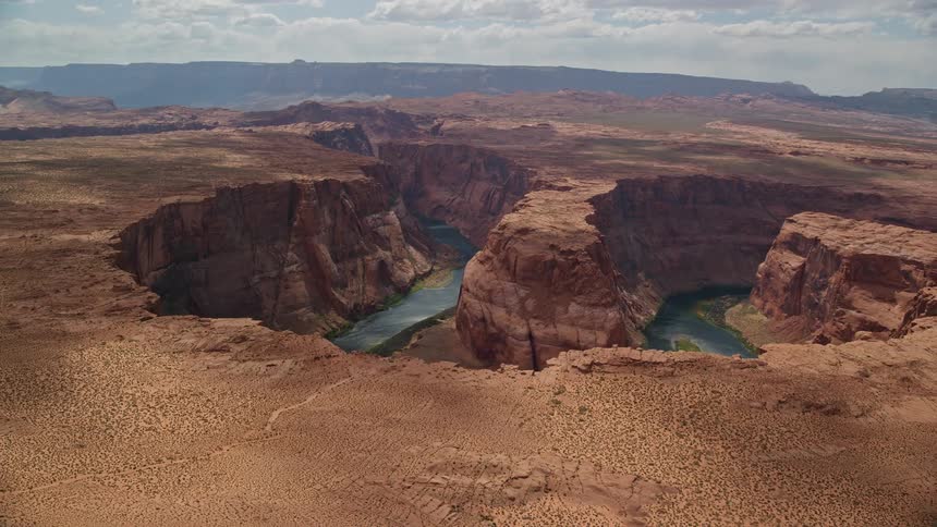  aerial footage captures a scenic flight over Horseshoe Bend and the Colorado River in Glen Canyon Arizona showcasing the natural beauty of the grand canyon and arid desert landscape