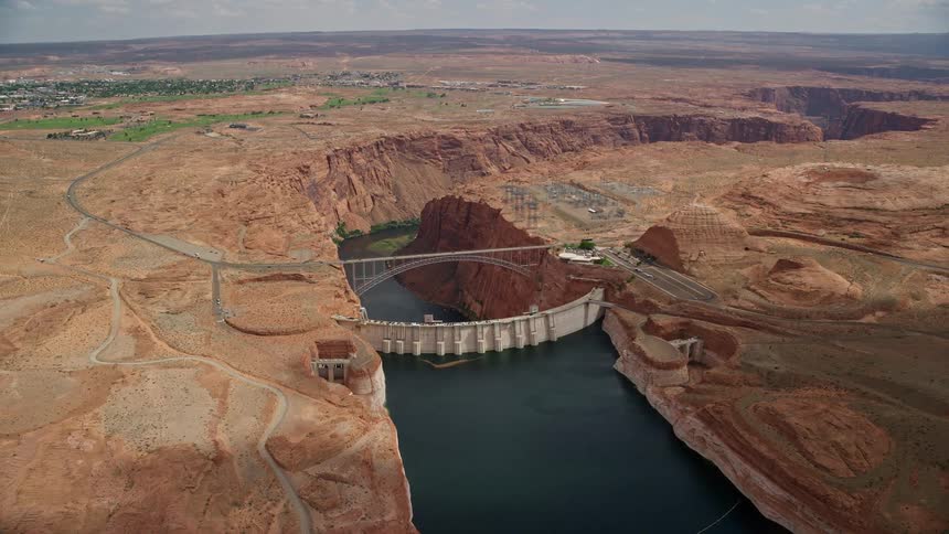  aerial footage of an approaching and tilting view of Glen Canyon Dam and Glen Canyon Dam Bridge in Arizona showcasing the natural beauty of the Southwest United States during summertime