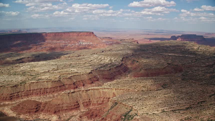Approaching narrow desert canyons in Navajo Nation Reservation Arizona and Utah captured in stunningaerial footage during a partly cloudy day in the Southwest United States showcasing the breathtaking natural beauty of the arid wilderness and native Ameri