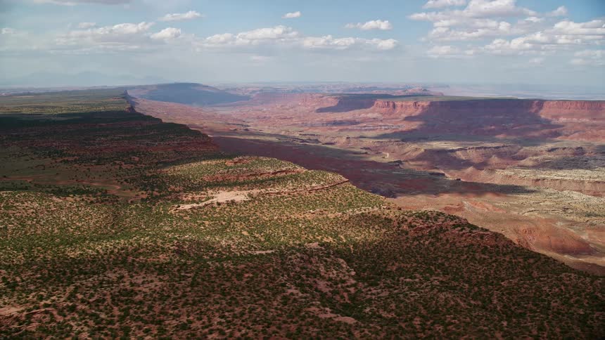 Aerial footage of a wide canyon with sparse vegetation located in the Navajo Nation Reservation in Arizona and Utah