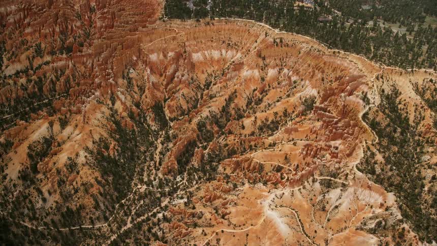 Aerial approach showcasing the stunning red rock formations buttes and hoodoos of Bryce Canyon National Park in Utah during summertime