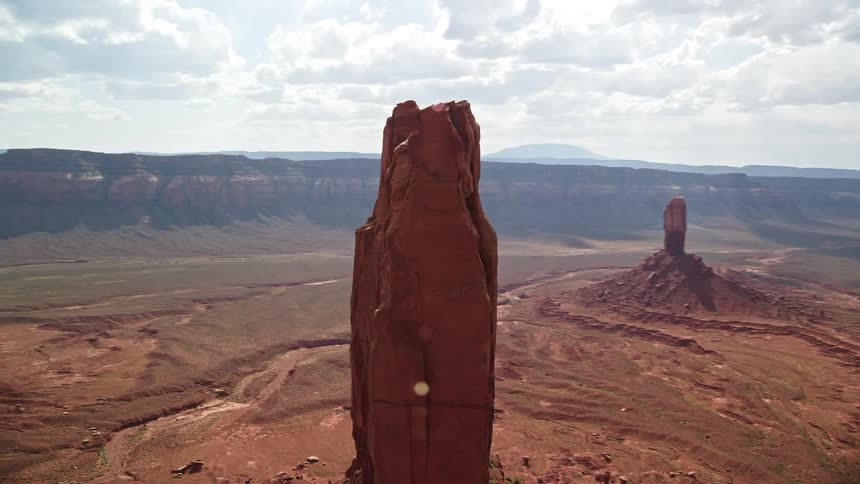 Aerial footage of a butte formation on the Navajo Nation Reservation in Arizona and Utah showcasing the natural beauty of the Southwest United States during a sunny day