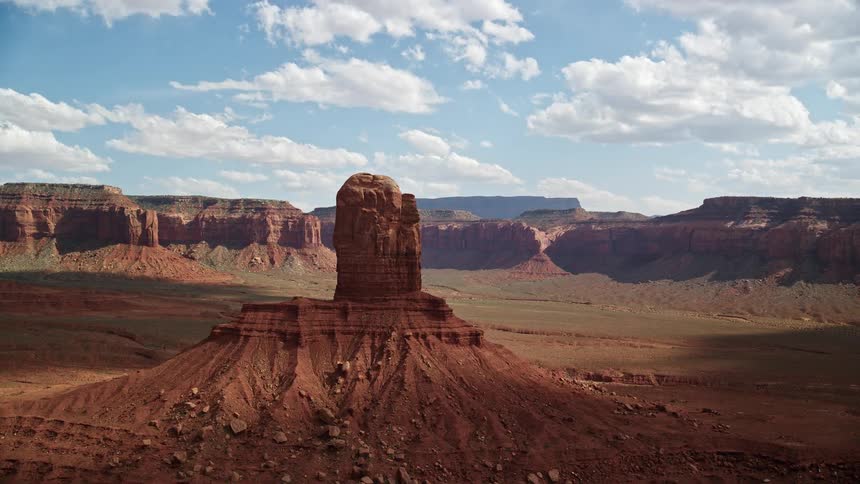  aerial footage of an orbiting tall butte surrounded by mesas on Navajo Nation Reservation in Arizona and Utah showcasing the stunning desert landscape and tribal lands