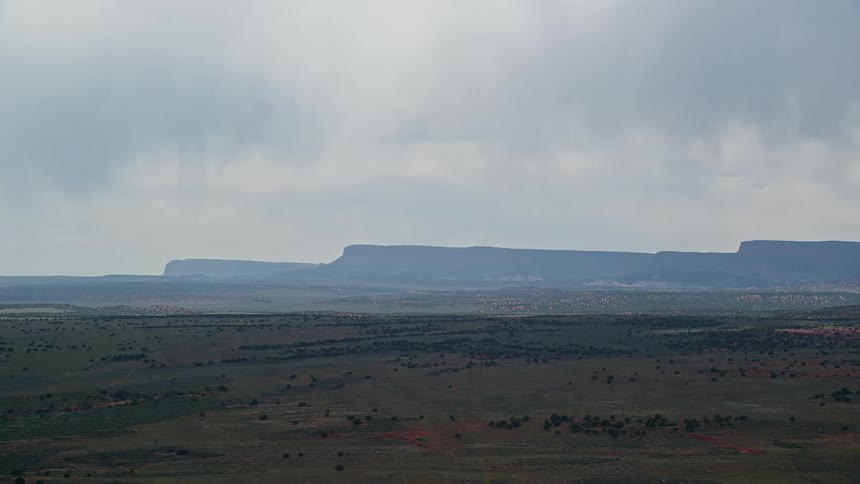 Aerial footage showcasing tall mesa cliffs in the Glen Canyon National Recreation Area Utah with a side view perspective and cloudy skies