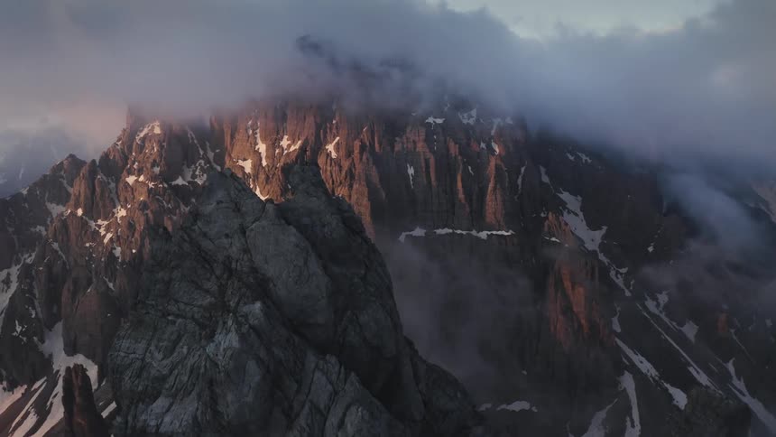 Aerial view of rugged mountains in clouds at sunset