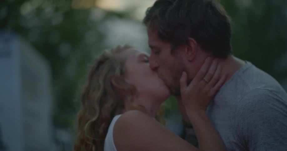 Man and woman kiss standing outside