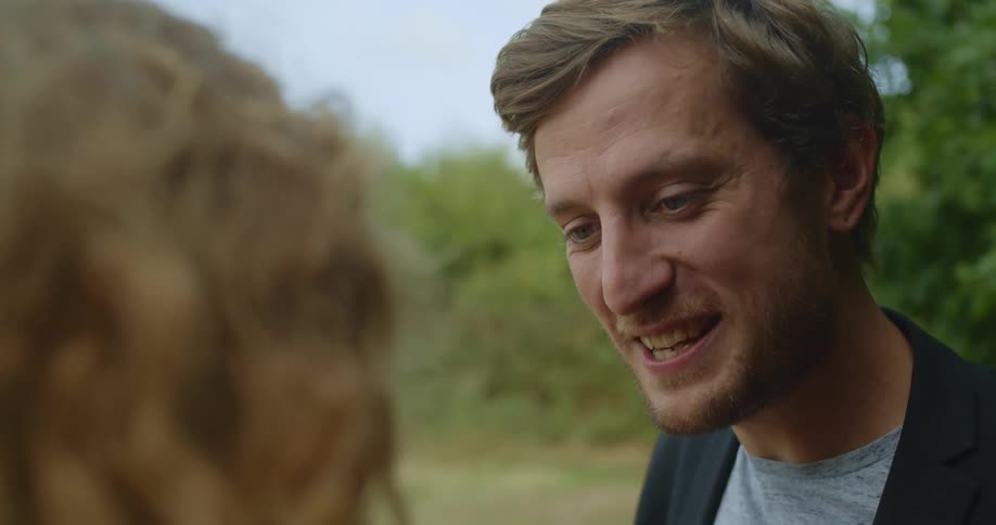 A man and a woman looking at each other and conversing with smiles