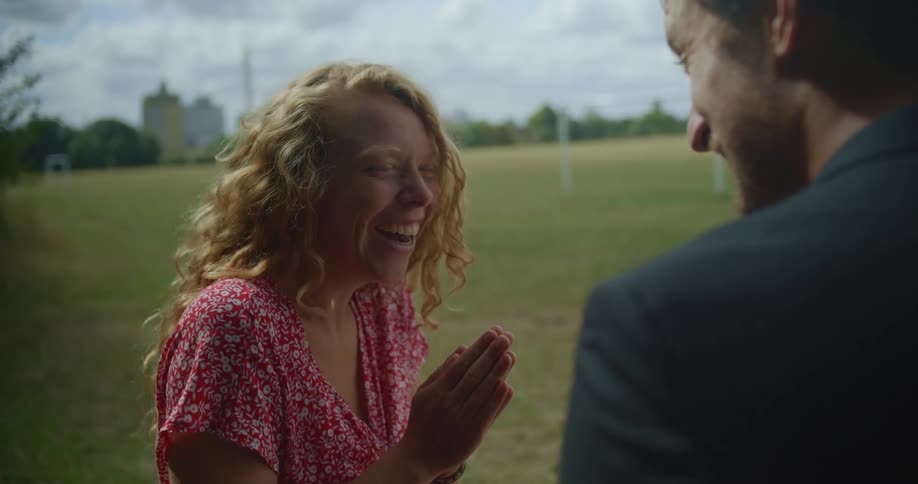 A woman reacts with surprise and excitement when her boyfriend proposes and gives her an engagement ring