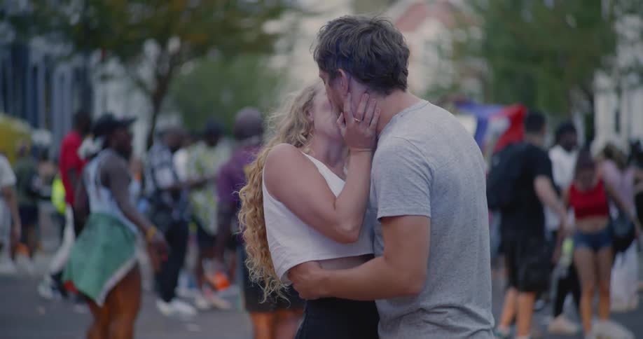 A couple kissing in a crowd at a celebration
