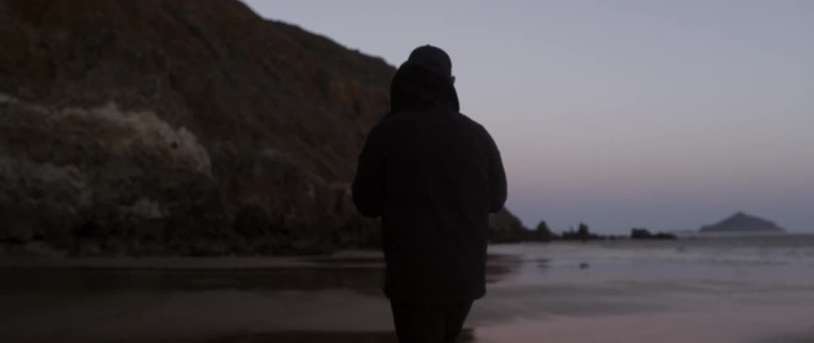 Man walks on a beach at sunset