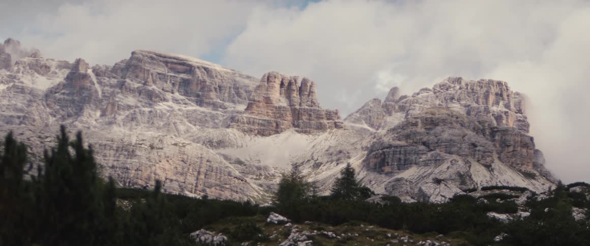 Red rock cliffs covered in snow on cloudy day