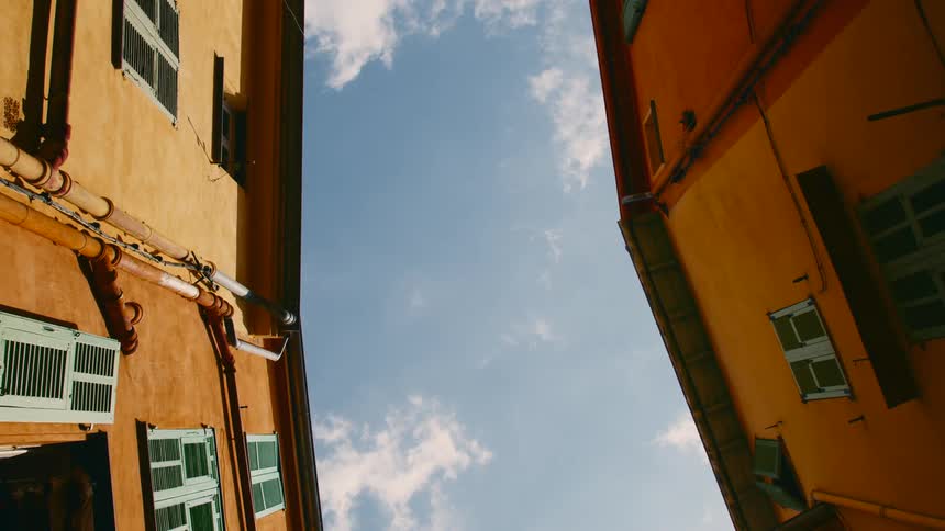 A bird flies over tall apartment buildings