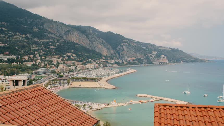 Aerial view of a suburban area by the seaside with yachts moored and the coastal waters nearby