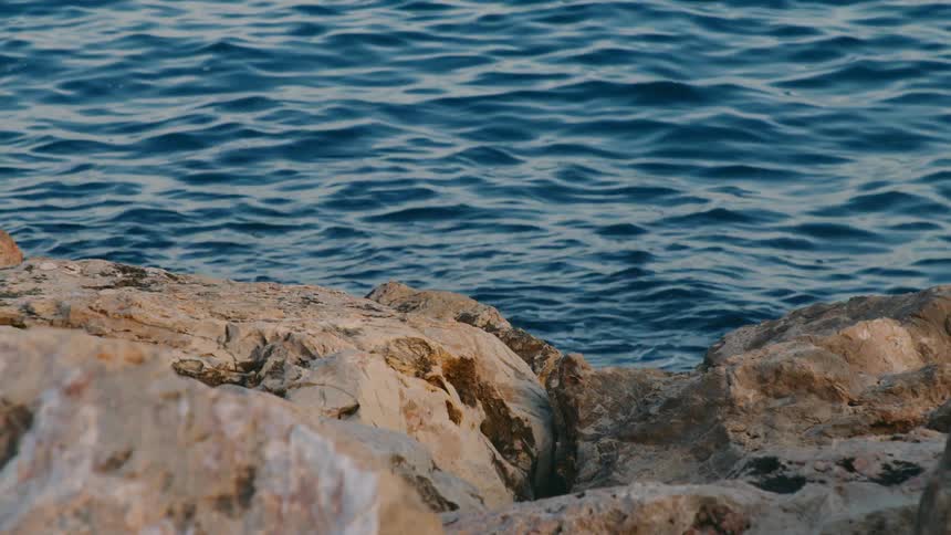 Closeup of a moving sea with rocks around