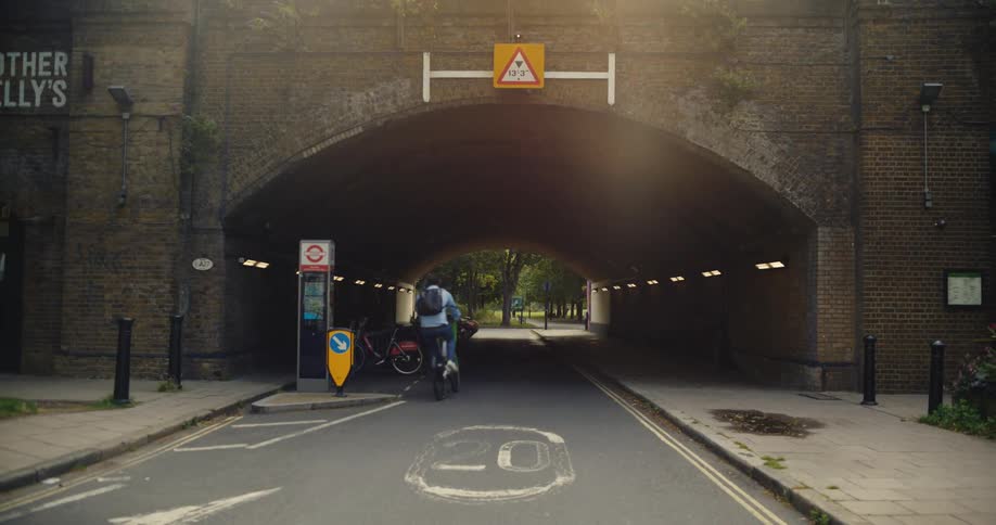Cyclist rides under railway bridge in London