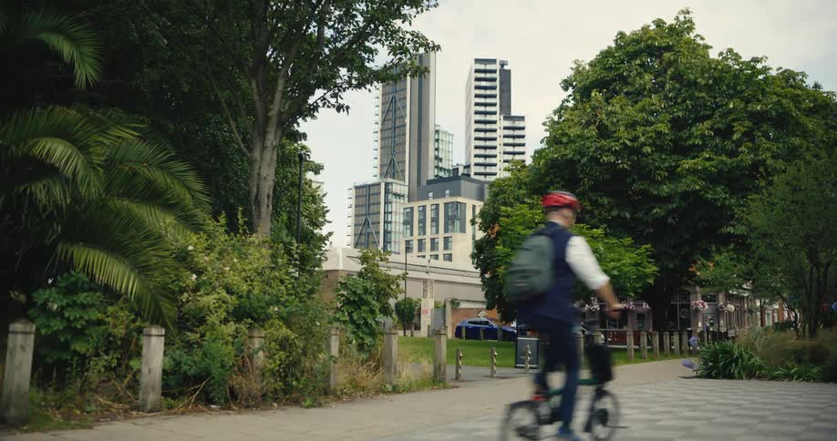 Commuters cycling through park in urban London