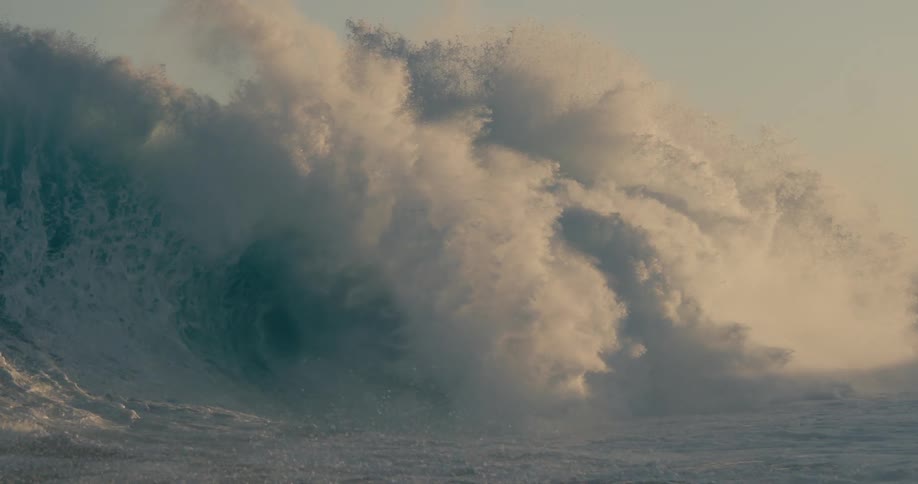 A large wave rises and falls in the ocean
