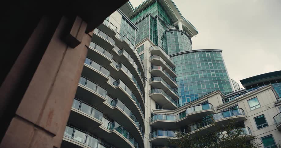 View up of modern block of flats with glass exterior in London on a cloudy day