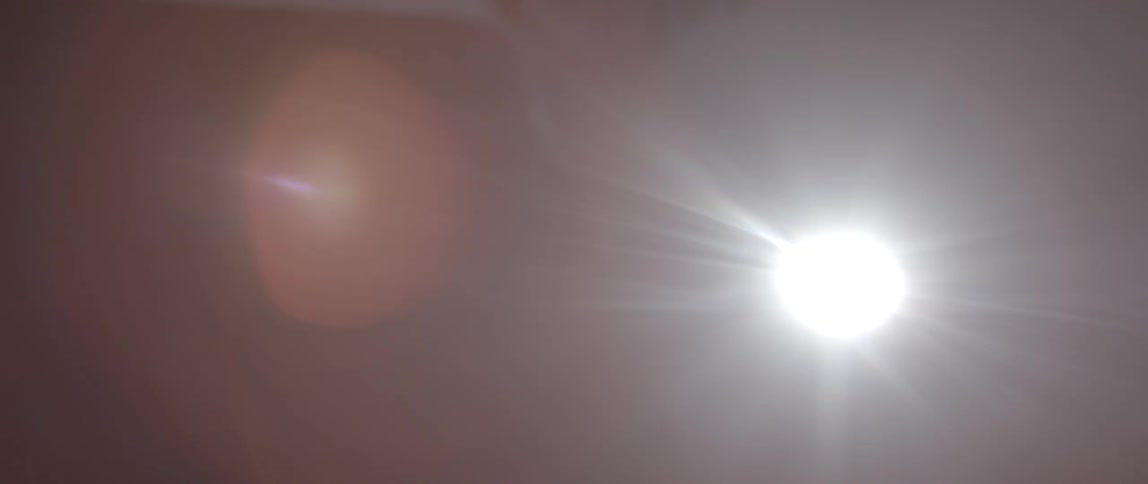 A person is walking around in a dark area with a spotlight in the background