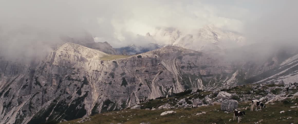 Snow dusted mountains and cliffs on cloudy day