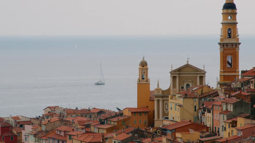 A boat sails by the city on the shore
