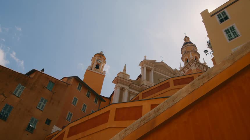Architecture of old buildings and residences with a clock tower bell and a church on a sunny day