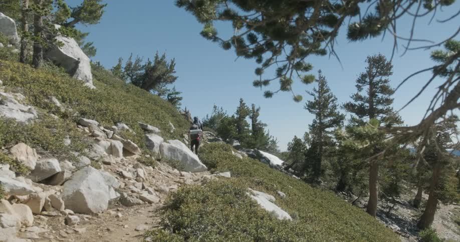 Hikers climb up rocky mountainside