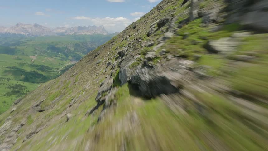 Grass grows around rocks on a vast mountain