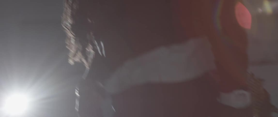 A man is moving past a large spotlight