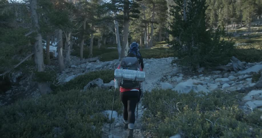 Two backpackers climbing a mountain