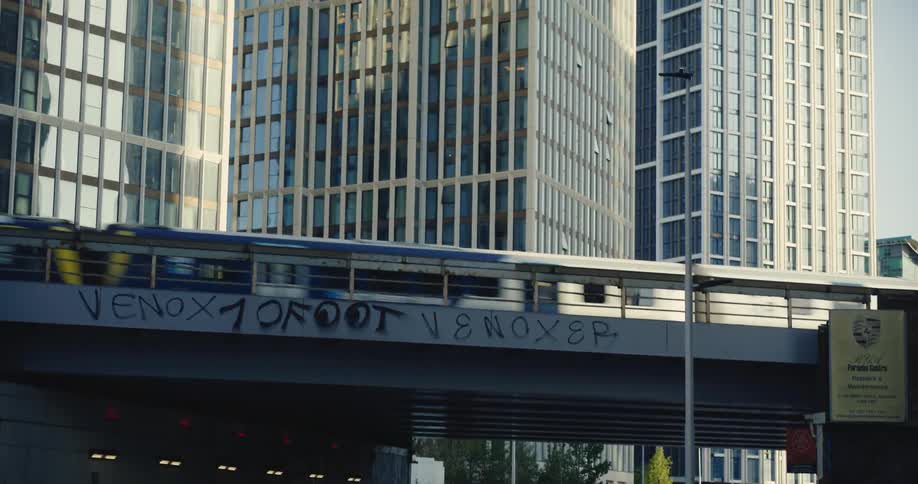 Train passing bridge with modern London skyscrapers behind