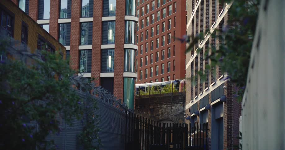 A train moves across a trestle behind downtown buildings