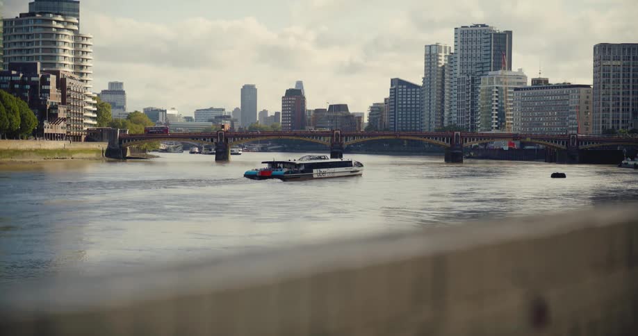 Thames Clipper Uber boat sailing towards Vauxhall Bridge with high rise buildings behind