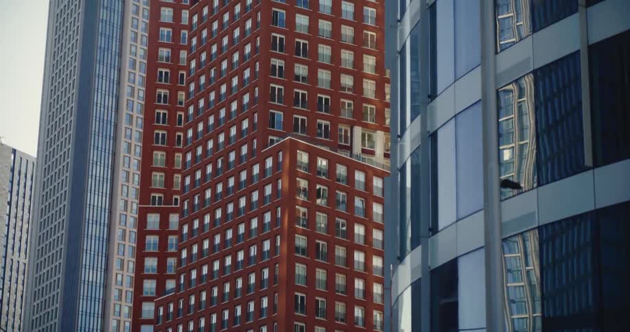 Vehicle passes by tall apartment buildings and offices in downtown London