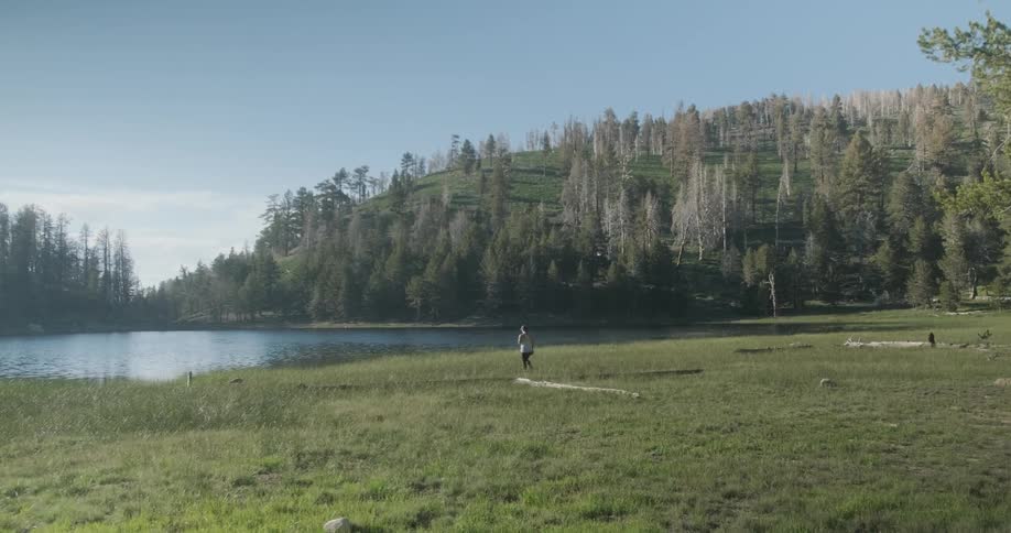 Person walking in mountain wilderness by a lake