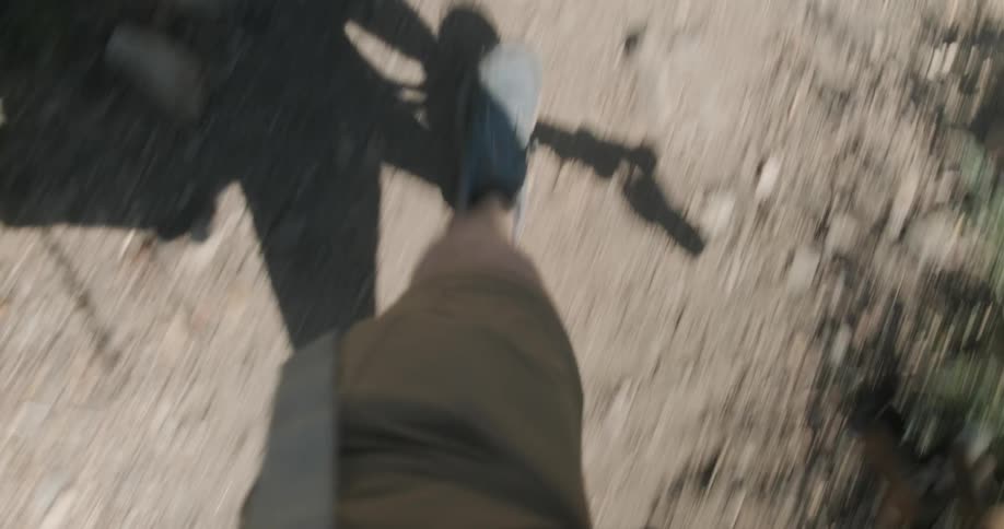 A hiker walks on a dirt path with hiking sticks