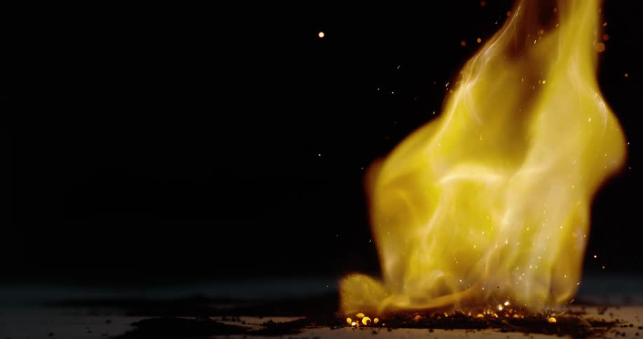 Sparks are ejected away from a pile of burning powder that is burning vigorously
