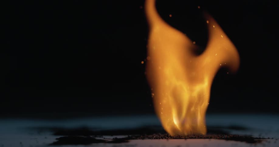 Slow motion of match lighting surface on fire and flames