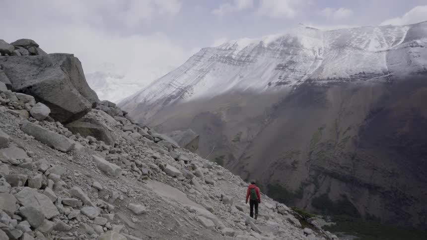 A hiker walks up a rocky mountainside