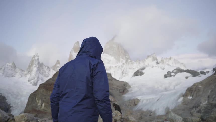 People hiking around snow covered mountain wilderness