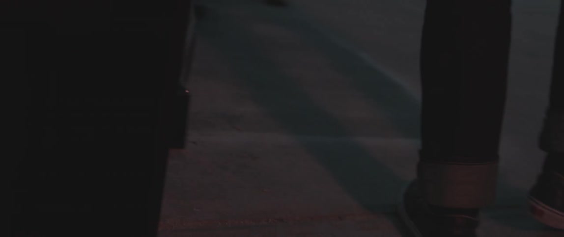 Person in sneakers walking on a city street  with rolled up jeans