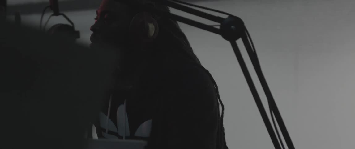 A man wearing headphones makes an adjustment to recording equipment