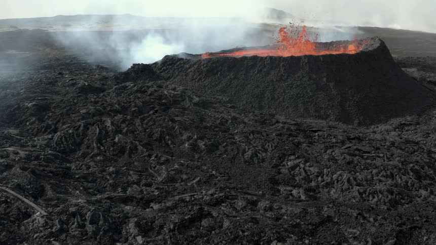Aerial view of an erupting volcano with magma and smoke around