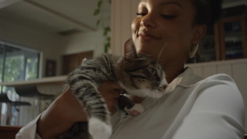 Woman holding a kitten and kissing its head
