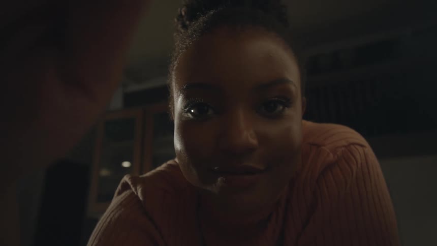 Young black woman with a joyful expression gently caressing the camera