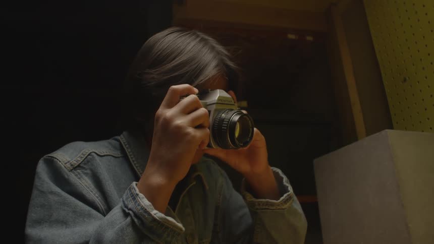 A young man is photographing a lizard in the aquarium