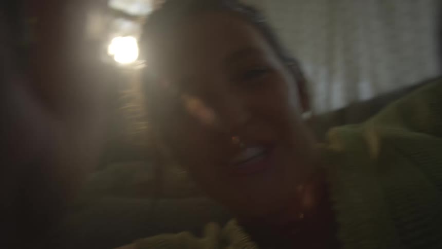 Young woman indoors smiling and playing during day time