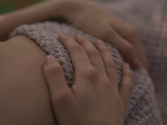 Mother rubs the back of her baby while resting outdoors
